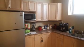 Coffee/tea maker, fridge, stovetop, cookware/dishes/utensils