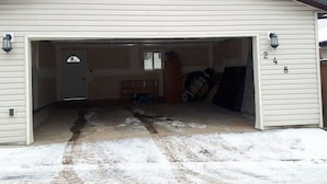 Un garage avec un toit sombre, une façade blanche et le numéro « 248 » peint sur le mur.