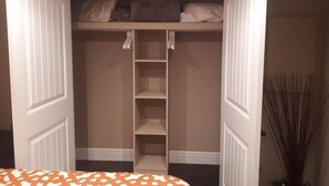 A walk-in closet with open doors, shelves, and hanging space.