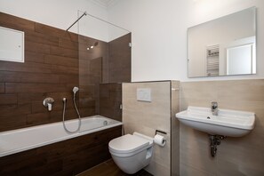 Une salle de bain moderne avec une baignoire, des toilettes et un lavabo.