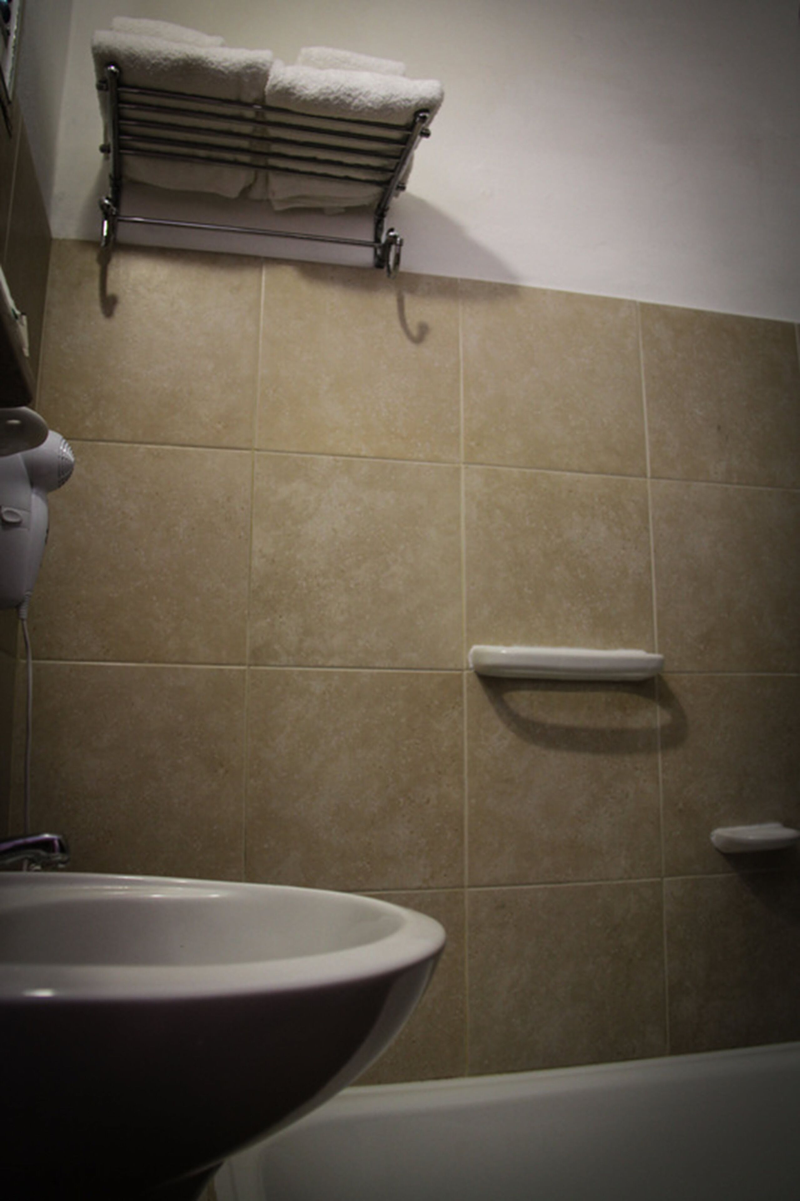 A bathroom with a sink, a towel rack, and a toilet.