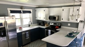 Una cocina moderna con electrodomésticos de acero inoxidable, horno empotrado y microondas.