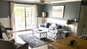 Una sala de estar con sofá, mesa de centro y mesa de comedor.