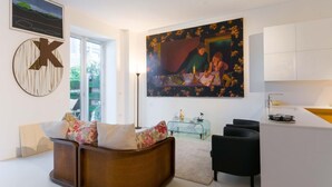 A modern living room with a sofa, a glass coffee table, and a painting on the wall. - 3J Luxury Loft (Milan)