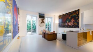 A modern living room with a large painting, a sofa, and a coffee table. - 3J Luxury Loft (Milan)