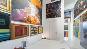 A hotel room with a large bed, a bedside table, and artwork on the walls. - 3J Luxury Loft (Milan)