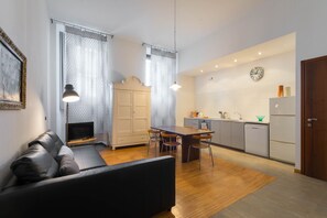 Un salon moderne avec un canapé, un téléviseur et un coin repas.