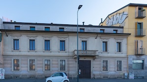 A historic building with a classic facade, a small car parked in front, and a street lamp nearby. - Naviglio 89 Apartment (Milan)