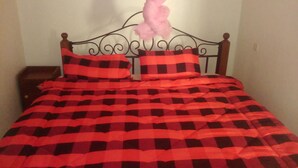 Una cama con una colcha a cuadros y almohadas.