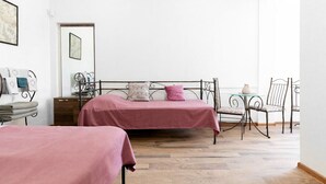 A bedroom with two beds, a small table, and a chair. - Studio Apartment on top of old Tbilisi with a 180 degree View of the city (Dzveli Tbilisi)