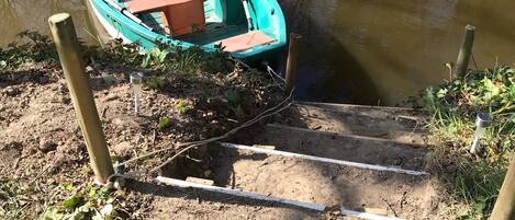 Un petit bateau est amarré à un quai par un poteau en bois.
