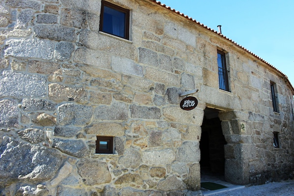 A stone building with a sign reading "Arco".