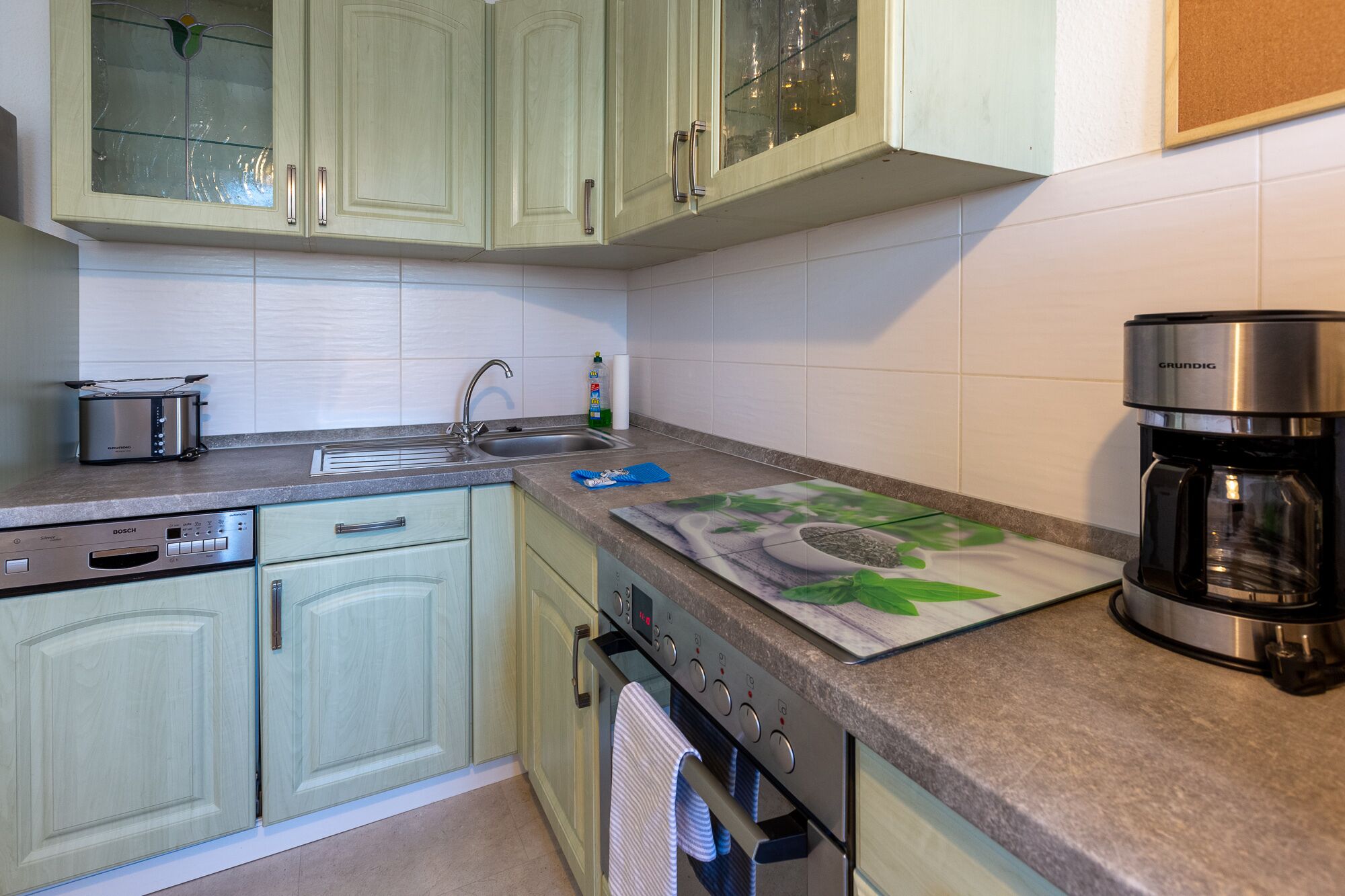 A kitchen with a Bosch dishwasher, a coffee maker, and a toaster.