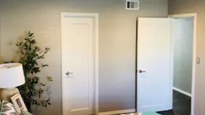 A room with a patterned carpet, a sofa, a lamp, and two doors. - 2 Bedroom Apartment near OU (Norman)