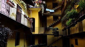 A multi-story building with balconies, some with plants and flowers. - navigli design week apartment (Milano)
