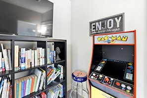 A room with a bookshelf, a Pac-Man arcade machine, and a TV. - Actually walkable to Georgetown Square with a private heated pool!
 (Georgetown)