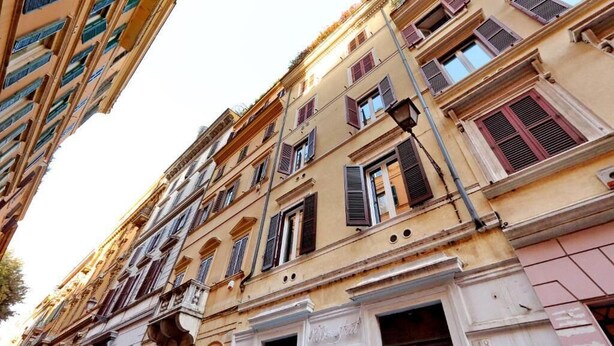 En rad av fler våningar höga byggnader med traditionella arkitektoniska detaljer, inklusive välvda fönster och dekorativa lister.