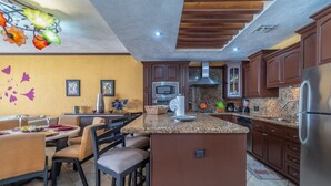 Una cocina moderna con encimeras de granito, electrodomésticos de acero inoxidable y armarios de madera.