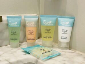 Vier flessen Eco Botanics producten op een badkamerplank.