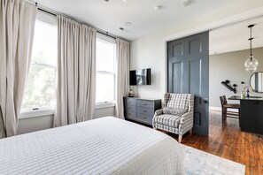 A bedroom with a bed, a dresser, a chair, a desk, and a door. - Modern Luxe Apartment - Close to City Center (Richmond)