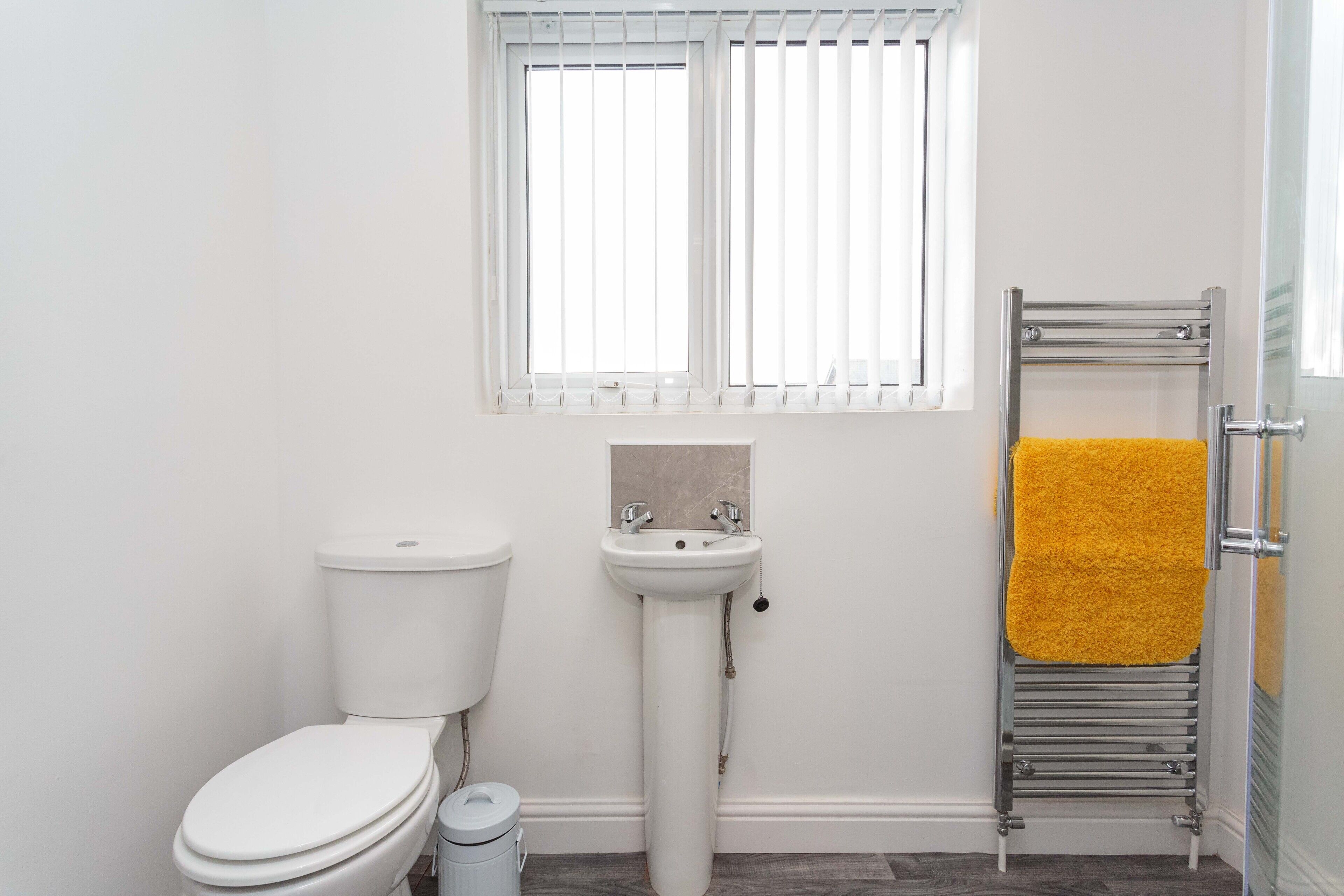 Ein Badezimmer mit Toilette, Waschbecken und Handtuchhalter.