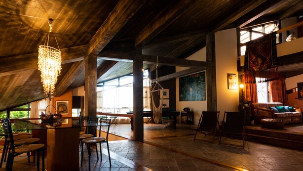 A spacious room with a high ceiling, a chandelier, a billiards table, and a cozy seating area with a couch and chairs. - Caloura 66 - Vacation Villa (Lagoa)