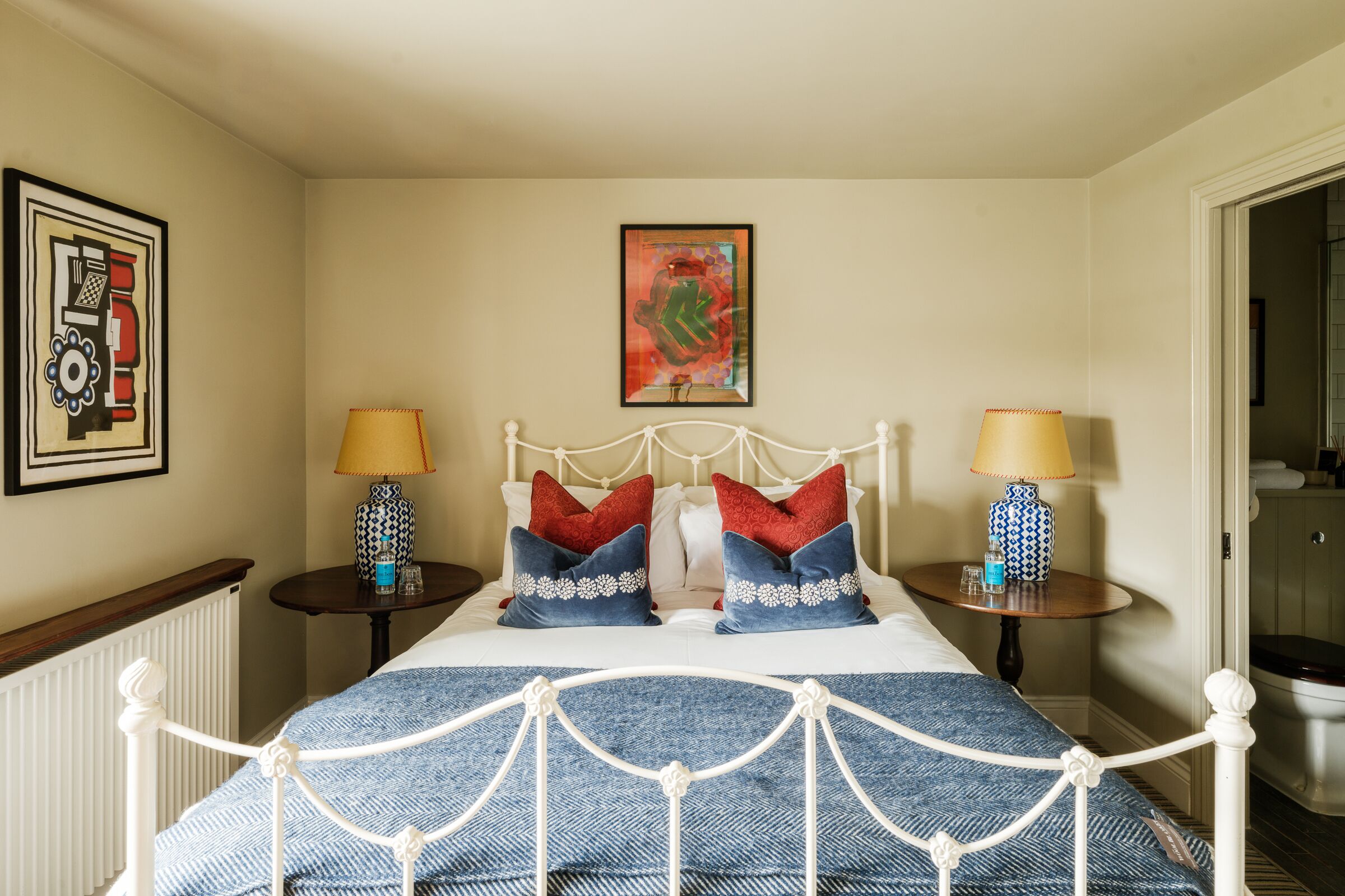 Un dormitorio ordenado con una cama, dos mesitas de noche y un cabecero.