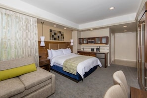 Relax in this stylish room with a large bed, sofa, and desk, perfect for work or unwinding.