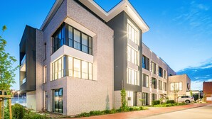 A modern multi-story building with large windows and a brick facade.