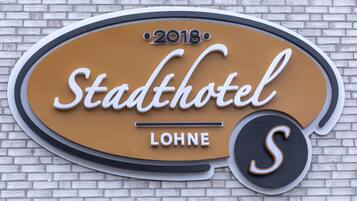 Skilt for Stadthotel Lohne med årstallet 2018.
