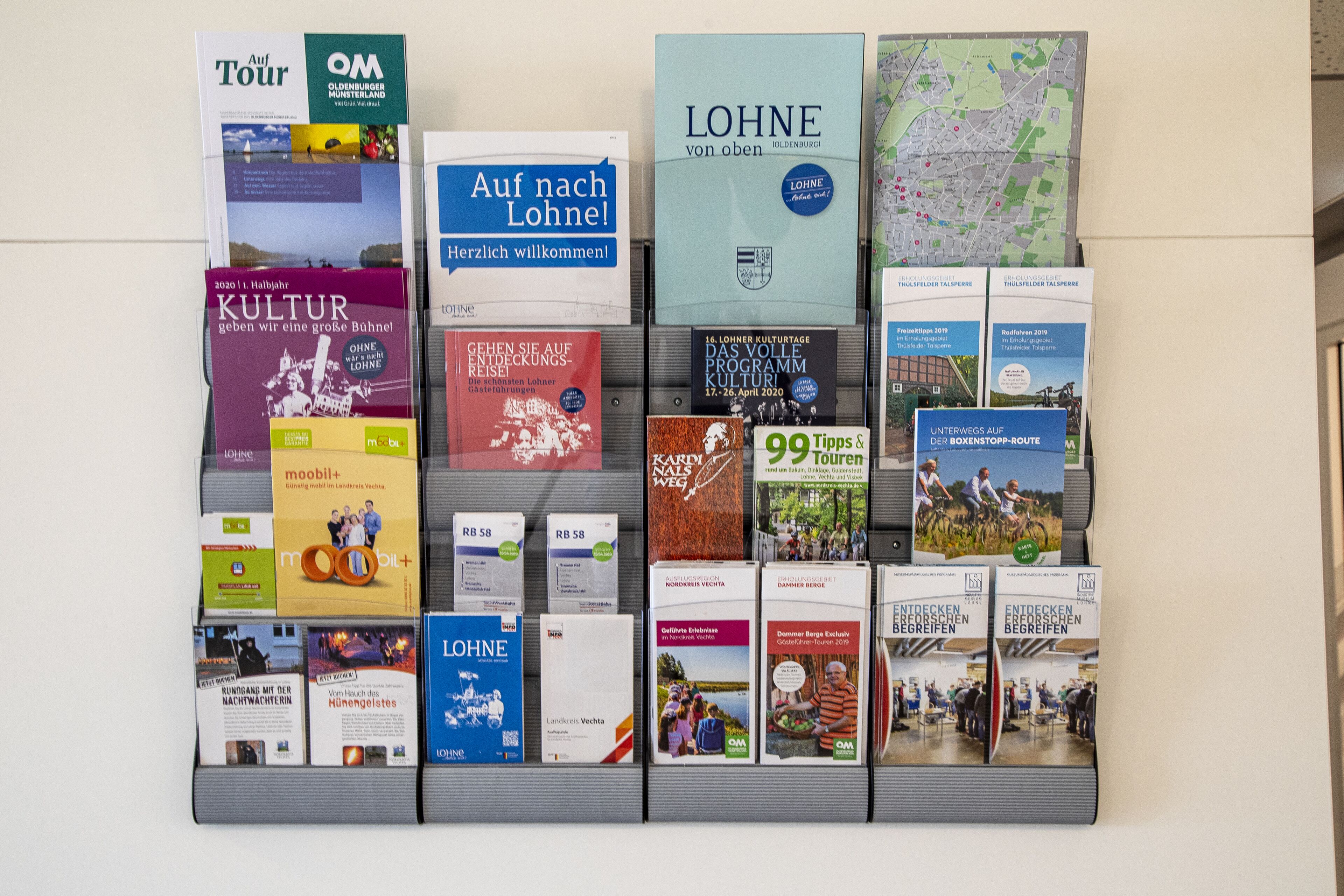A wall displaying various informational brochures and maps.