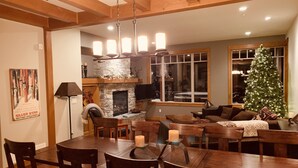 A cozy living room with a fireplace, a dining area, and a Christmas tree. - Amazing Upgraded Chalet with Everything You Need and It's ALL Yours - No Suite (Silver Star Mountain)