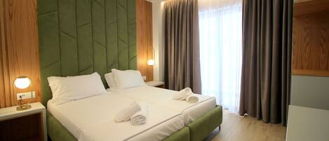 A double bed with two pillows and a bedside table with a lamp.