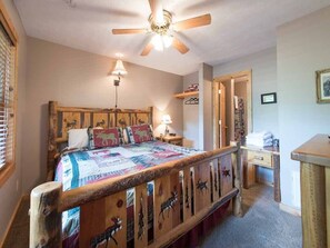A bedroom with a wooden bed, a ceiling fan, a bedside lamp, and a desk with a chair. - Running Bear, 2 Bedrooms, Hot Tub, Gas Fireplace, Pool Table, Sleeps 8 (Gatlinburg)