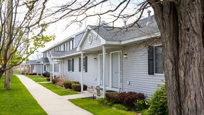 A row of single-story houses with attached garages, neatly aligned along a sidewalk.