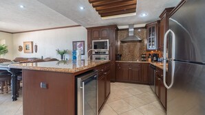 Una cocina moderna con encimeras de granito, electrodomésticos de acero inoxidable y armarios de madera.