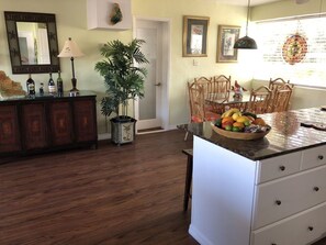 A kitchen with wooden cabinets, a dining table with chairs, a fruit bowl, and a potted plant. - Fabulous Waterfront Pool Two Level Home  (Islamorada)