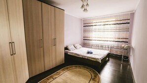 Ein Schlafzimmer mit einem Bett, einem Kleiderschrank und einer kleinen Sitzecke.