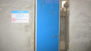 A blue door with a sign instructing to take off shoes. - The Happy Family House (Angkor Borei)