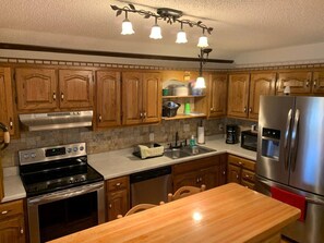 A kitchen with wooden cabinets, a stainless steel refrigerator, a stove, and a dishwasher. - QUIET PRIVATE BLUFF TOP HIDEAWAY, CLOSE TO EVERYTHING (Guntersville)