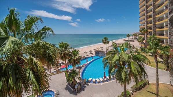 A resort with a pool, beach, and ocean view.