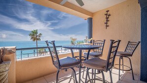 A balcony with a table and chairs, overlooking the ocean. - Princesa Resort E-408 Relaxation Clean Great Ocean Front Condo (Puerto Peñasco)