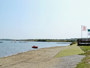 A beach with a sandy shore, a grassy area, and a body of water with boats. - 2 bedroom accommodation in Mount Hawke, near Redruth (Mount Hawke, near Redruth)