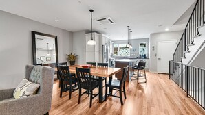 Una cocina moderna con zona de comedor, suelo de madera y una escalera.