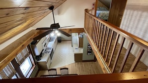 A wooden interior with a kitchen area, a ceiling fan, and a staircase. - Close to Hurley, Trail access, near The Gile Flowage with Central Air & King Bed (Montreal)