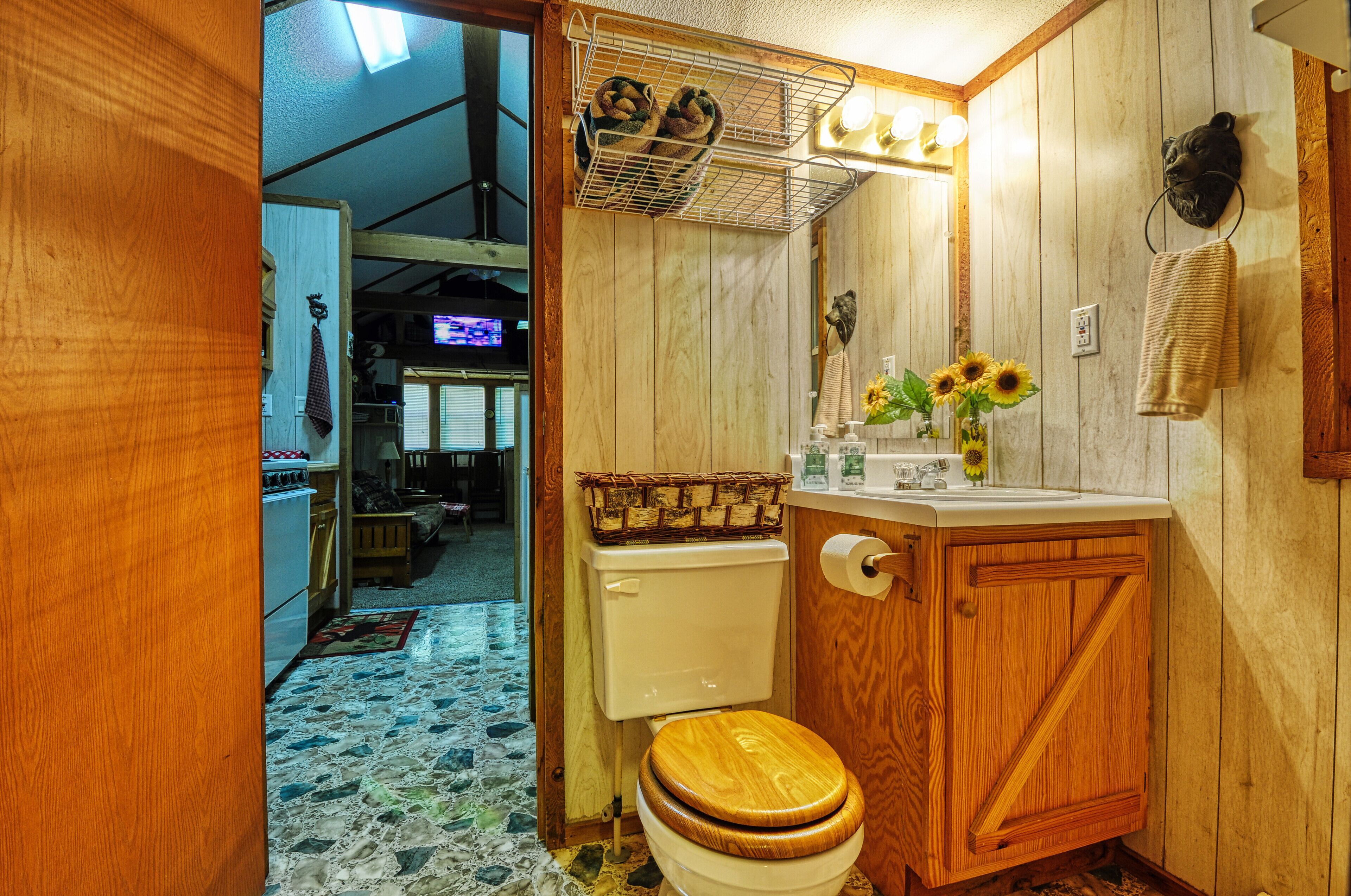 Une salle de bain en bois avec des toilettes, un lavabo et un miroir.