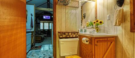 Une salle de bain en bois avec des toilettes, un lavabo et un miroir.