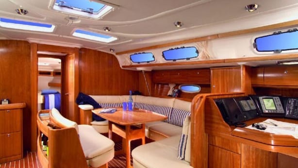 A luxurious interior with a wooden deck, a cozy seating area with cushions, and a control panel.