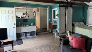 Et værelse med teal vægge, en seng, et skrivebord og en garderobe.