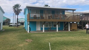A two-story house with a balcony, a front porch, and a garage. - Beachfront Home with Outstanding Beach Views; Quick Walk to Ocean. (Matagorda)